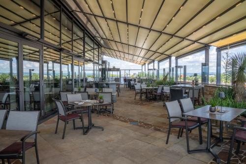 a restaurant with tables and chairs and windows at Best Western Plus Arosa Hotel in Paderborn