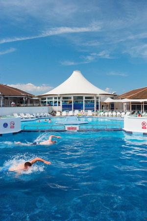 two people swimming in the water in a swimming pool at 29 sea reach in Allhallows