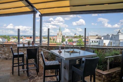 a patio with a table and chairs and a view of a city at Best Western Plus Arosa Hotel in Paderborn