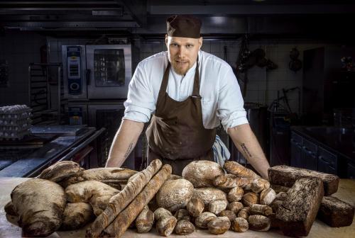 a man standing in front of a pile of food at Hotel Klaus K in Helsinki