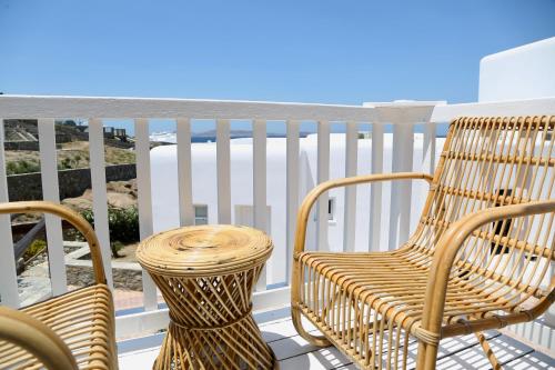 a pair of chairs and a table on a balcony at Ubud Mykonos in Agios Ioannis Mykonos