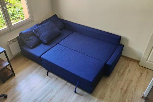 a blue couch in the corner of a room at La maison du bonheur in Biscarrosse