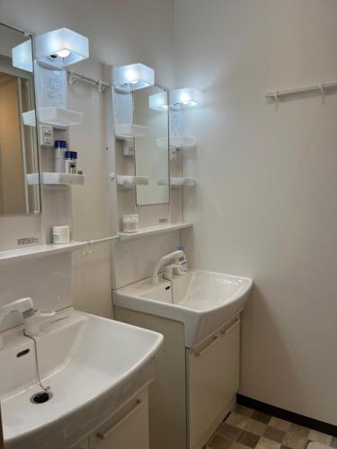 a white bathroom with a sink and a mirror at Inari-Home in Kyoto
