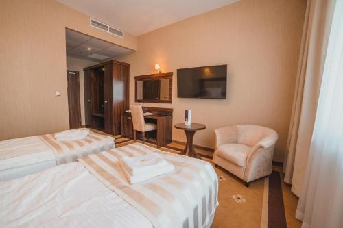 a hotel room with two beds and a chair at Hotel Binkowski in Kielce