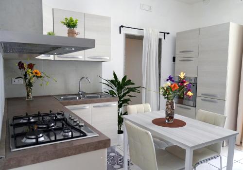 una cucina con tavolo bianco e piano cottura forno superiore di Home Civico 19 a Sannicandro di Bari