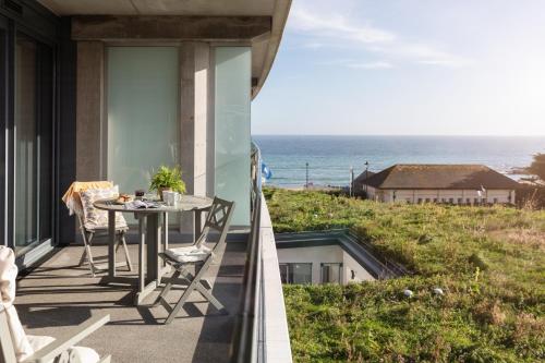 a balcony with a table and a view of the ocean at St Michaels The Liner in Falmouth