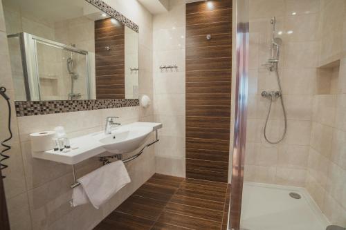 a bathroom with a sink and a shower at Hotel Binkowski in Kielce