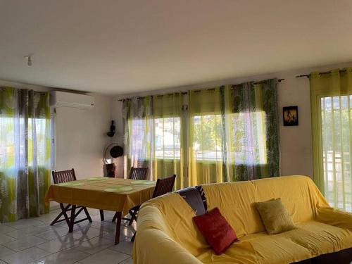 un soggiorno con divano giallo e tavolo di Location chambres Mtsapéré Maevantana sur Mamoudzou Mayotte chez Zam a Mamoudzou