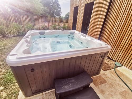 un jacuzzi dans une cour arrière avec une clôture dans l'établissement Villa Lodge Sauternes Darroze, à Sauternes