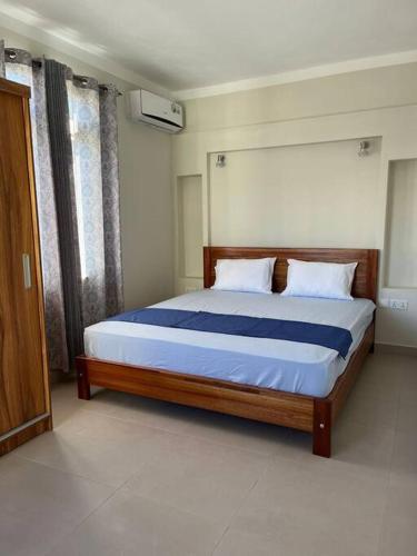 ein Schlafzimmer mit einem großen Bett mit blauer Bettwäsche in der Unterkunft Pearl Gate Residence Apt No 3 in Flic-en-Flac