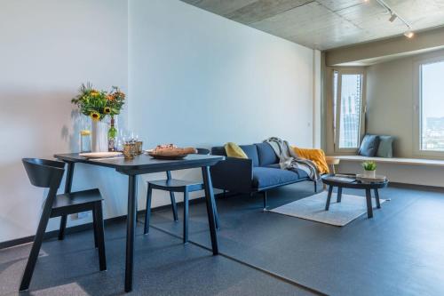 uma sala de estar com uma mesa e um sofá em District Living em Viena