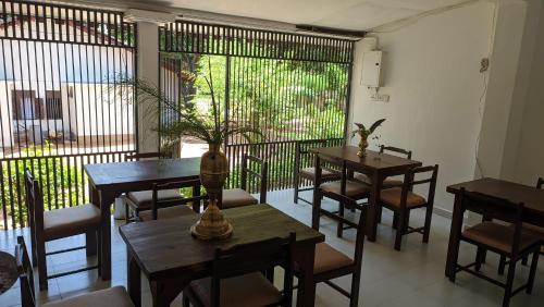 a restaurant with tables and chairs and a large window at Verandas Trincomalee in Trincomalee