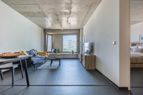 uma sala de estar com um sofá e uma mesa em District Living em Viena