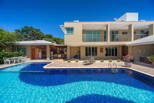 a large swimming pool in front of a house at Casa Fênix in Porto Seguro