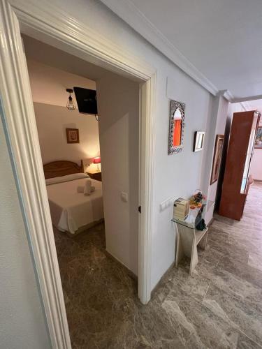a room with a bedroom with a bed and a doorway at Apartamentos COZYNNS II in Torremolinos
