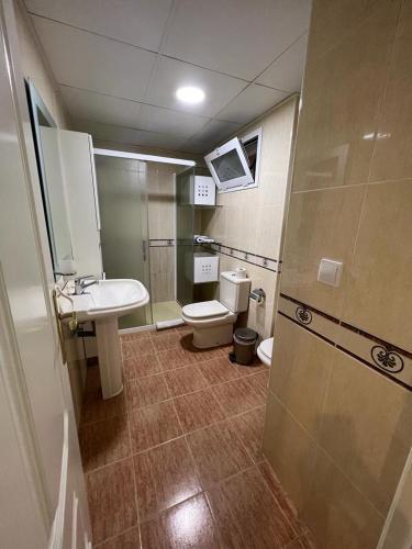 a bathroom with a toilet and a sink at Apartamentos COZYNNS II in Torremolinos