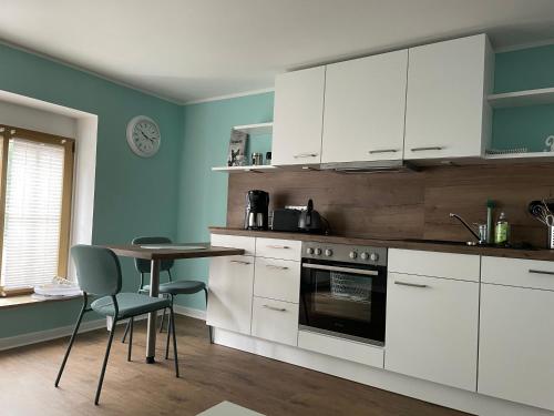 a kitchen with white cabinets and a table at Altstadtperle Nideggen in Nideggen