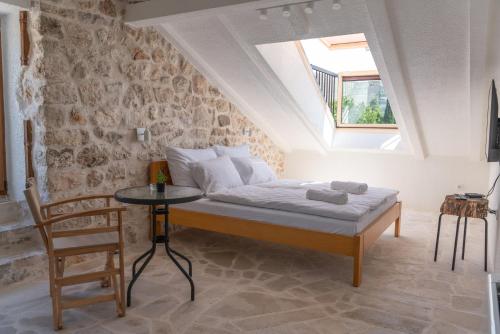 Schlafzimmer mit einem Bett, einem Tisch und einem Fenster in der Unterkunft Hotel Restoran Humsko in Trebinje