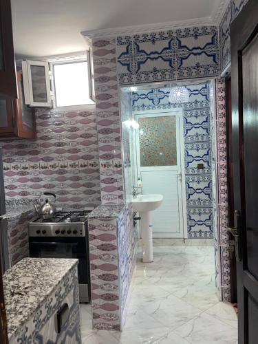 cocina con fogones y fregadero en Superbe maison avec terrasse à hay mohamedi, en Agadir