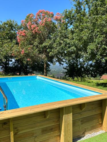 einen Pool mit einer Holzterrasse und Bäumen in der Unterkunft Casa O Corvo, chalet cerca de Vigo en plena naturaleza 