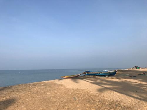 un barco sentado en una playa de arena junto al agua en Spice of Ceylon en Chilaw