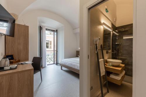 een badkamer met een bed en een badkamer met een wastafel bij Dimora dei Celestini in Manfredonia