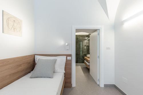 a small bedroom with a bed and a hallway at Dimora dei Celestini in Manfredonia