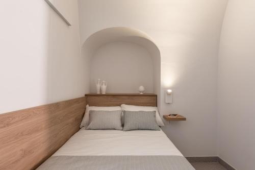 a bed in a white room with an arch above it at Dimora dei Celestini in Manfredonia