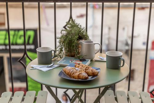 a table with a plate of croissants and two cups at Dimora dei Celestini in Manfredonia