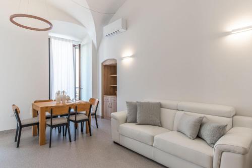 ein Wohnzimmer mit einem weißen Sofa und einem Tisch in der Unterkunft Dimora dei Celestini in Manfredonia