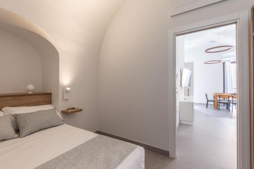 a white bedroom with a bed and a dining room at Dimora dei Celestini in Manfredonia