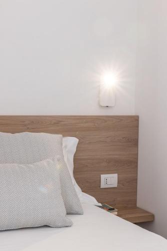 a bed with a wooden headboard with a light above it at Dimora dei Celestini in Manfredonia
