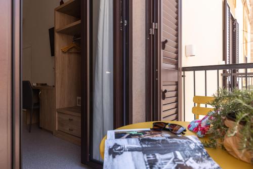 a room with a table and a balcony with a mirror at Dimora dei Celestini in Manfredonia