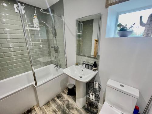 ein Badezimmer mit einem Waschbecken, einer Badewanne und einem WC in der Unterkunft Weavers Cottage, Sleeps 6, outside terrace in Buxton