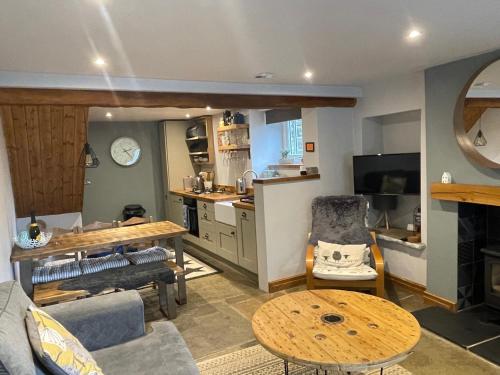 a living room with a table and a kitchen at Weavers Cottage, Tideswell, sleeps 6, dog friendly in Buxton