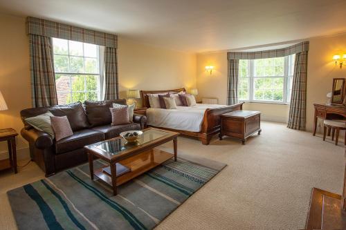 a living room with a bed and a couch at Boreham House in Herstmonceux