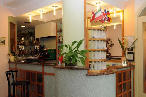 a bar in a restaurant with a counter with chairs at Hotel Flora in Bellaria-Igea Marina