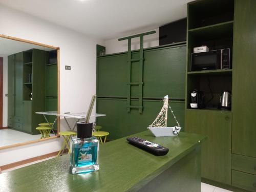 uma sala verde com um controlo remoto no balcão em Monolocale a due minuti dal mare IUN R4225 em Marina di Portisco