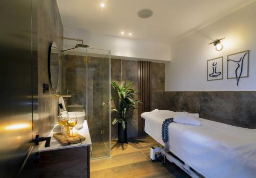 a bedroom with a bed and a glass shower at Pool, Sauna, Gym & Spa @ Beach-Front Apartment Hotel in Ashqelon