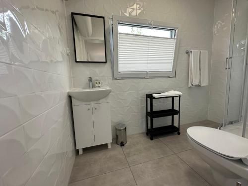a white bathroom with a sink and a toilet at Sun House 