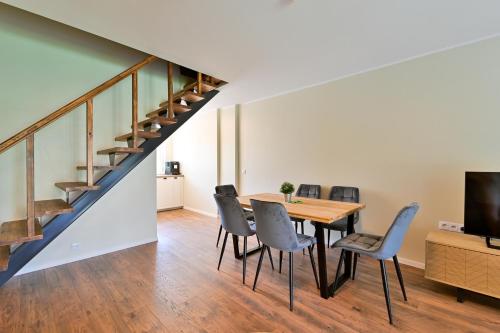 ein Esszimmer mit einem Tisch, Stühlen und einer Treppe in der Unterkunft Kuressaare Pikk Apartment in Kuressaare