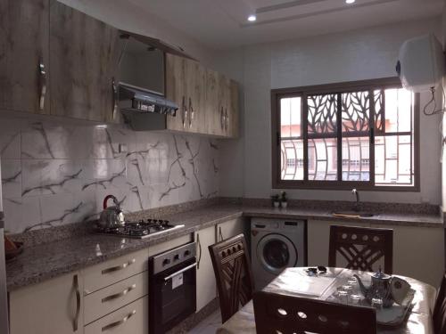a kitchen with a sink and a stove top oven at Sweet Room Airport 5 in Deroua