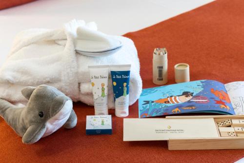 a stuffed animal next to a book and some cosmetics at InterContinental Marseille - Hotel Dieu by IHG in Marseille