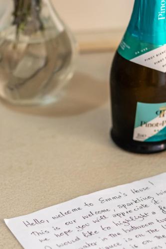 a handwritten note next to a bottle of wine at Emma's House in Sasseta