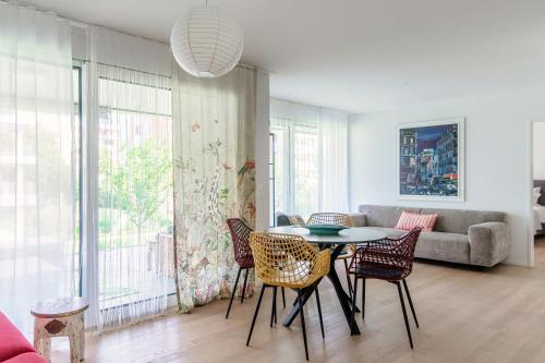 un soggiorno con tavolo, sedie e divano di Suite Parco Lago by Quokka 360 - Terraced flat close to Lido Locarno a Locarno