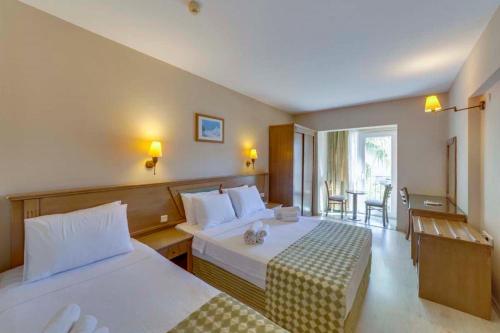 a hotel room with two beds and a balcony at Smart Stay Beach Bodrum -All Inclusive in Gümbet