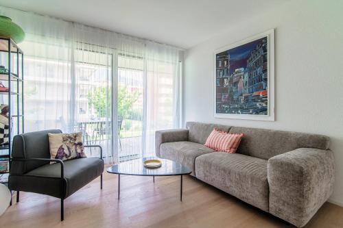 a living room with a couch and a chair at Suite Parco Lago by Quokka 360 - Terraced flat close to Lido Locarno in Locarno