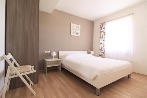 a bedroom with a white bed and a window at Apartment Vita in Funtana