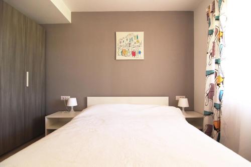 a bedroom with a large white bed and two tables at Apartment Vita in Funtana