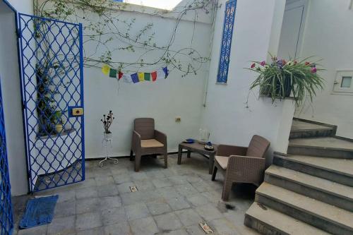 a room with two chairs and a table and stairs at La Maisonnette Turquoise in Dar Mimoun Bey